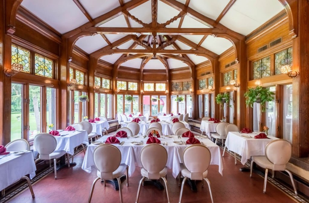 Edgars Steakhouse Solarium 2019-024 BEHU-608-HDRLR Edgars Steakhouse Solarium with neatly setup tables and chairs.